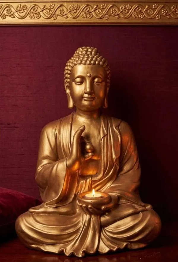 Golden Buddha statue and candles in the serene Venus Spa Lisboa setting