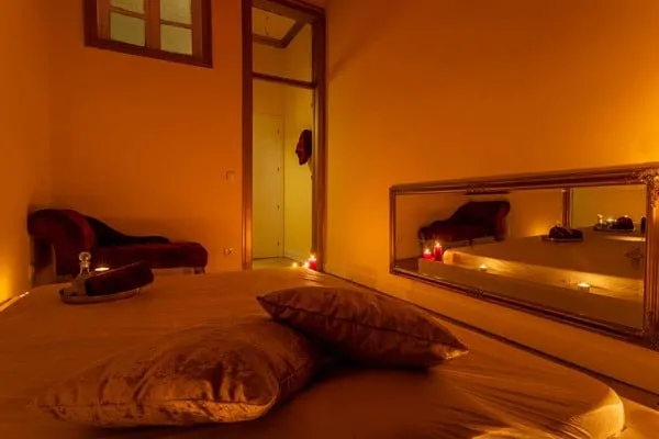 Warm massage room with chaise and mirror at Venus Spa Lisboa