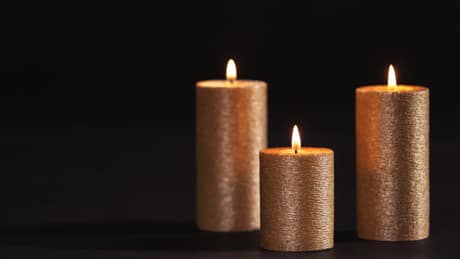 Velas douradas acesas sobre fundo escuro, ambiente do Venus Spa Lisboa