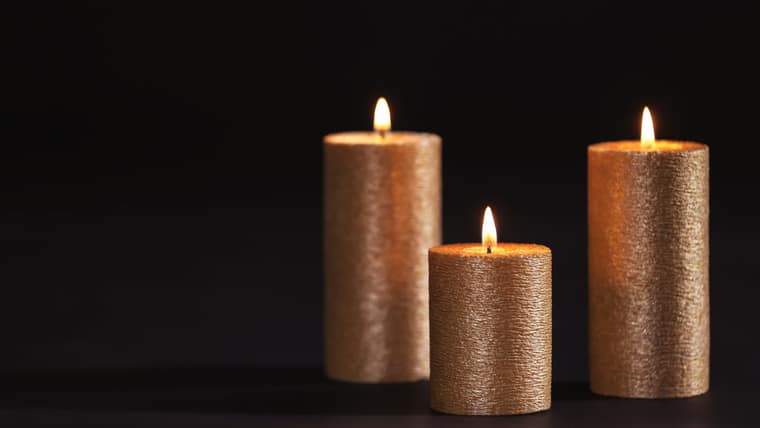 Velas douradas acesas sobre fundo escuro, ambiente do Venus Spa Lisboa